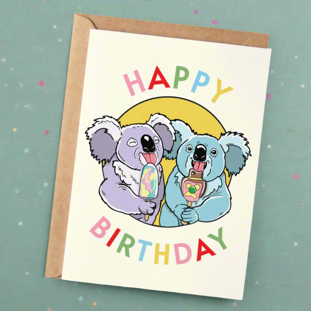 Birthday card with two koalas holding ice cream cones and colorful 'Happy Birthday' text.