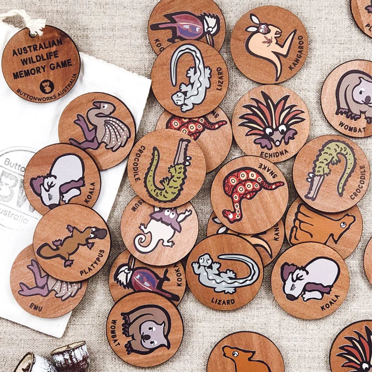 Collection of wooden memory discs with Australian wildlife illustrations on a textured fabric background.